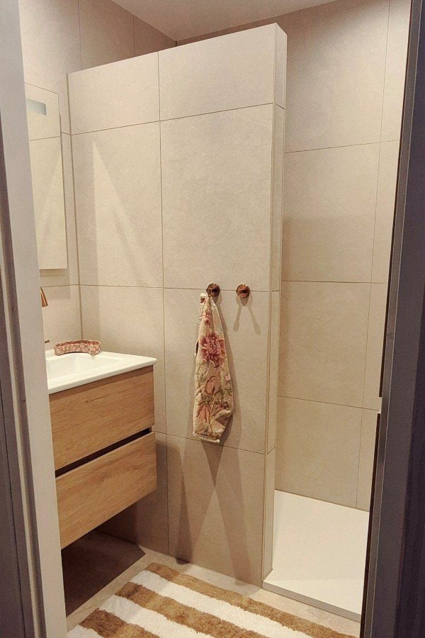 Petite salle de bains avec meuble en bois, carrelage effet béton,  douche à l'italienne