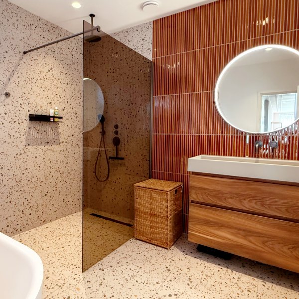Moderne badkamer met terrazzo tegels en oranje kitkat tegel