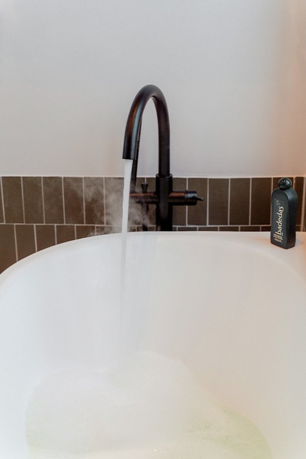 Zwarte badkraan groene tegels