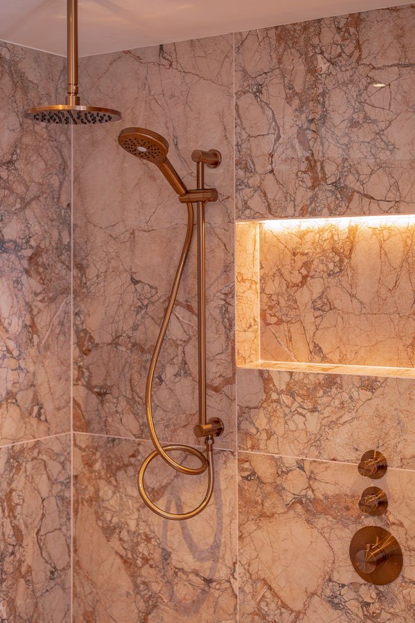 Roze marmerlook douche met koperen kranen