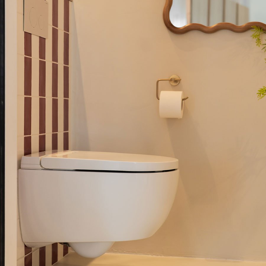 Moderne beige toiletruimte met rood witte streep tegel