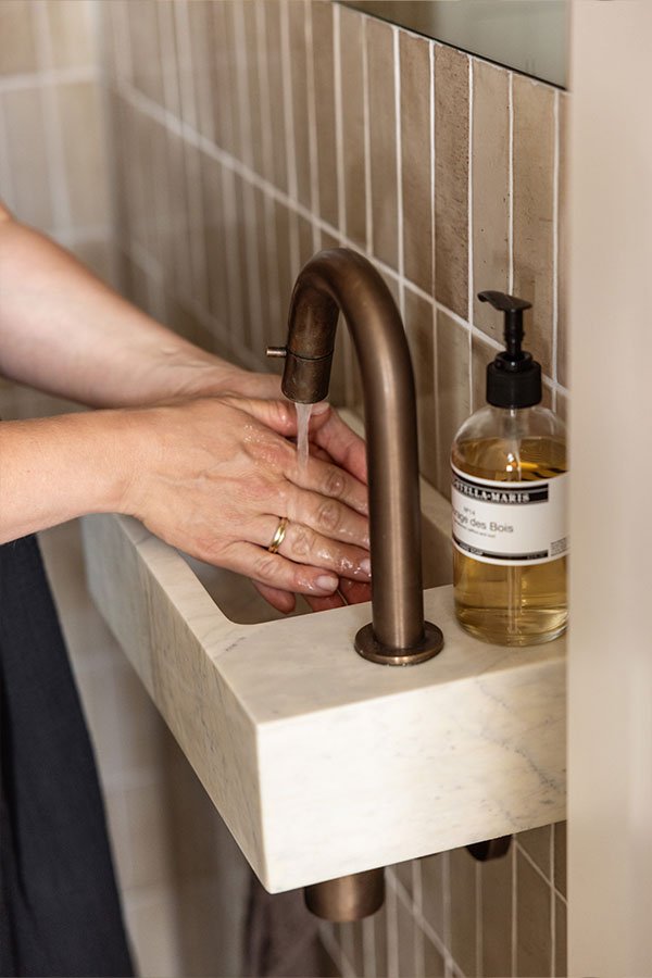 Marmeren wasbakje met gouden fonteinkraan